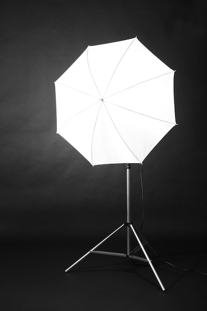 Flash de estudio con paraguas sobre fondo gris