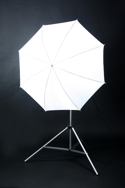 Flash de estudio con paraguas sobre fondo gris