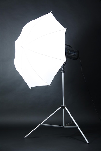 Flash de estudio con paraguas sobre fondo gris