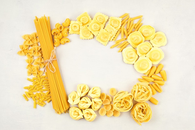 Flat lay com diferentes tipos de massa tradicional italiana. Penne, tagliatelle, fusilli, farfalle, spaghetti e outros. Conceito tradicional da culinária italiana. Vista do topo