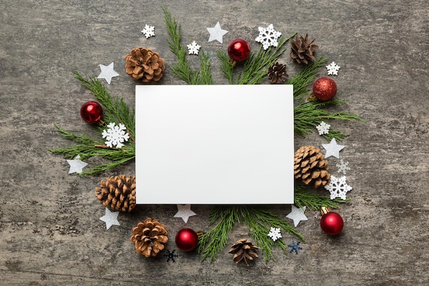 Flat lay Composición de Navidad cuadrado Papel en blanco ramas de pino decoraciones navideñas sobre fondo de color Vista superior espacio de copia para texto