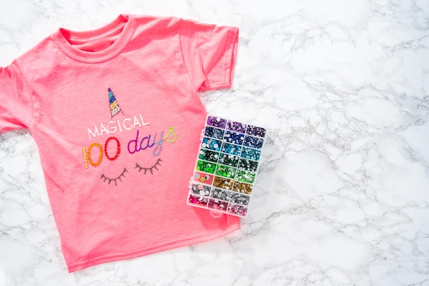 Flat lay Decorando camisetas de niñas para la celebración de los 100 días de la escuela