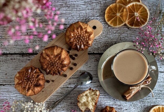 Flat lay delicioso desayuno navideño panecillos caseros y una taza de café con leche en primer plano de fondo claro de madera