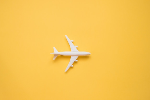 Flat lay design do conceito de viagens com avião em amarelo