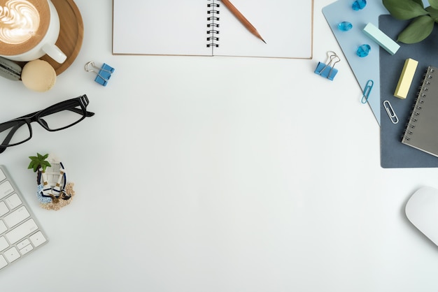 Flat lay, espaço de trabalho de escritório vista superior com o caderno em branco, teclado, material de escritório.