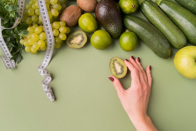 Foto flat lay frutas y verduras con kiwi mano