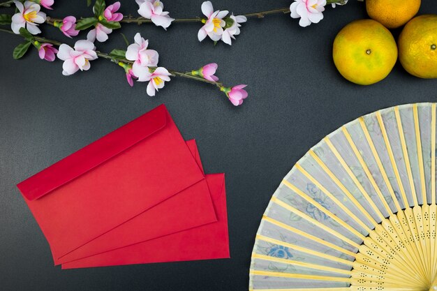 Flat lay holiday of chinese new year pacote vermelho e de acessórios flor no topo