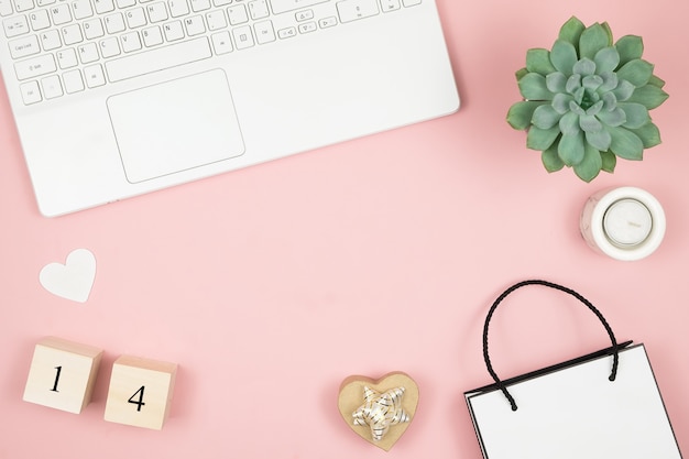 Flat lay home escritorio de oficina. Espacio de trabajo para mujeres con laptop y decoración en superficie rosa. Concepto de día de San Valentín