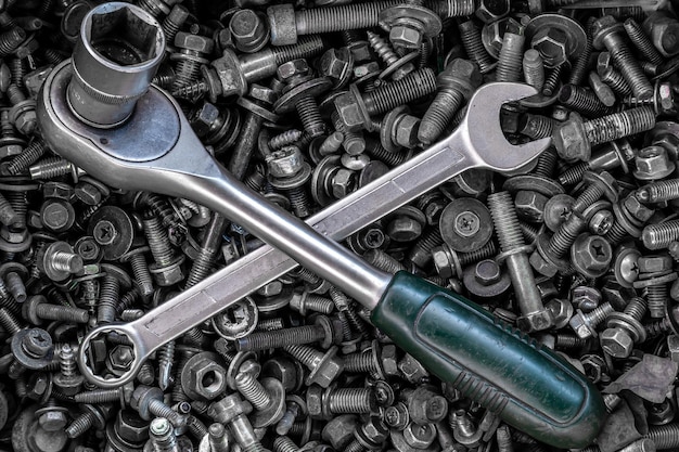 Flat Lay Metallschlüssel und Ratschen unterschiedlicher Größe liegen auf dem Hintergrund verschiedener Metallzahnräder, Schrauben und Nägel Draufsicht Closeup Carpenter's Tool Kit