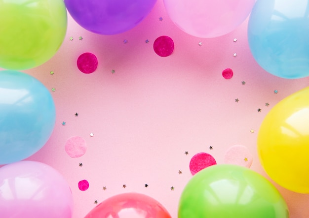 Flat Lay mit Geburtstagsballons, Konfetti und Bändern auf Pink