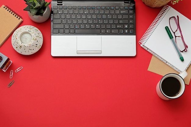 Flat lay moderno escritorio de trabajo con laptop, gafas, teléfono inteligente, taza de café.