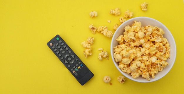 Flat lay popcorn em uma tigela com controles remotos de TV em um fundo azul