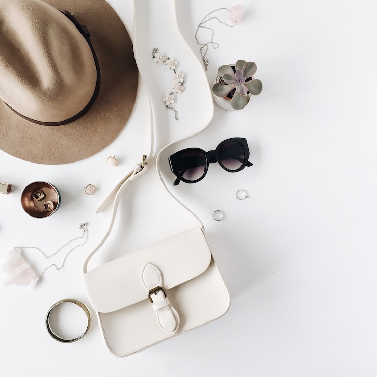 Foto flat lay trendige kreative feminine accessoires arrangement. geldbörse, hut, sonnenbrille, weibliche accessoires.