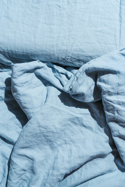 Flatlay aus blauen Leinenbetttüchern und Kissen, Morgenkonzept