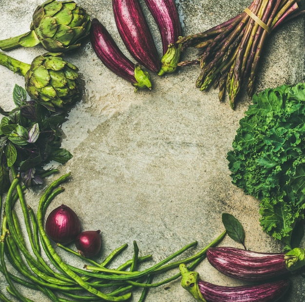 Flatlay aus grünem und violettem rohem Gemüse auf grauem Hintergrund