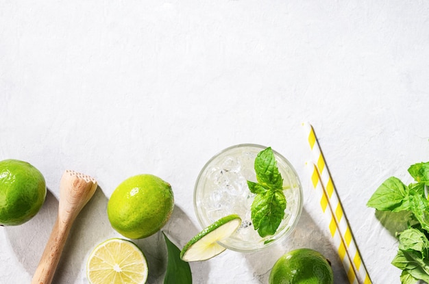 Flatlay de cóctel mojito con menta fresca de lima y hielo sobre fondo de textura blanca Refresco de verano bebida cítrica Vista superior y espacio de copia