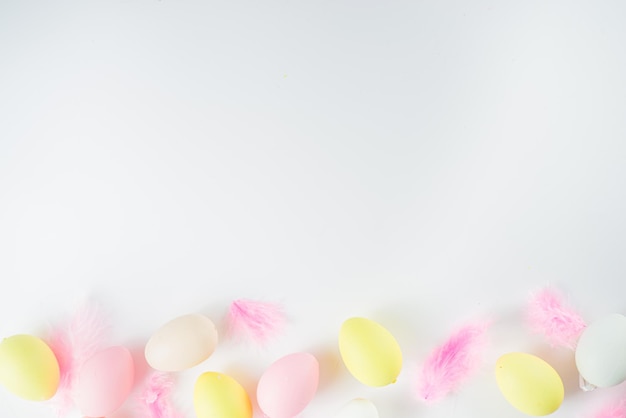 Flatlay de color pastel con huevos de Pascua y plumas en mesa blanca Concepto de vacaciones de primavera de fondo de patrón simple de Pascua