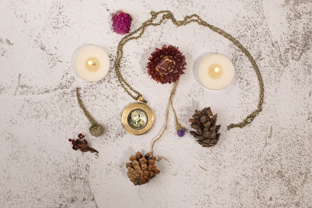 Flatlay com medalhão, velas e flores secas. Foto de alta qualidade