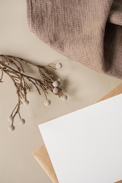 Flatlay de modelo de marca de negócios com estilo parisiense estético cartão de folha de papel em branco com espaço de cópia de maquete ramo de flores secas e pano em fundo bege neutro vista superior plana