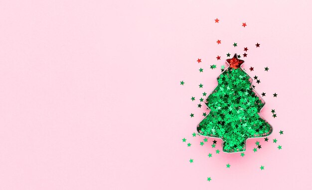 Flatlay de natal com árvore de natal verde decorativa em fundo rosa com espaço de cópia.