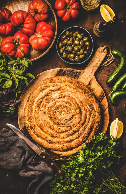 Flatlay der türkischen Borek-Torte mit Spinatfüllung und Gemüse