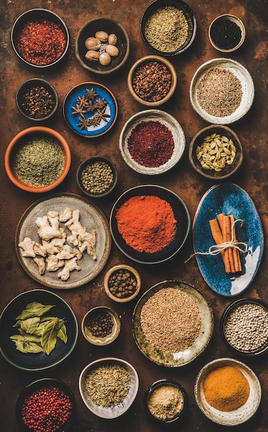 Flatlay de diversas especias en tazones sobre fondo oxidado