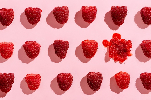 Flatlay de frambuesas dispuestas en rosa