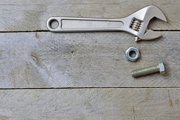 Flatlay. Llave ajustable y perno sobre un fondo de madera. Copie el espacio.