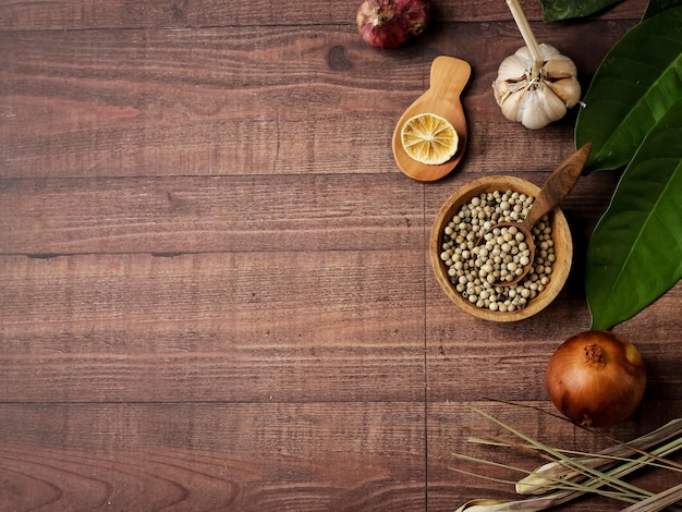 Flatlay mit verschiedenen Kochgewürzen auf braunem Holztextur-Kopienraum