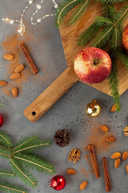 Flatlay navideño de manzanas, nueces, canela y ramas de árboles. El concepto de Navidad y año nuevo. Tarjeta de felicitación.