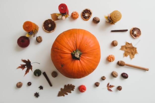 Flatlay otoñal y composición acogedora con velas de calabaza hojas sobre fondo blanco vista superior