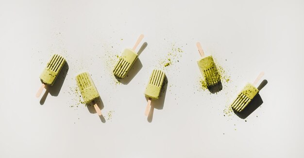 Flatlay de paletas caseras de coco matcha verde con té en polvo