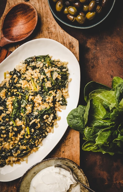 Flatlay de plato tradicional turco Bulgur y espinacas a bordo