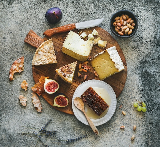 Flatlay de surtido de quesos higos miel y frutos secos