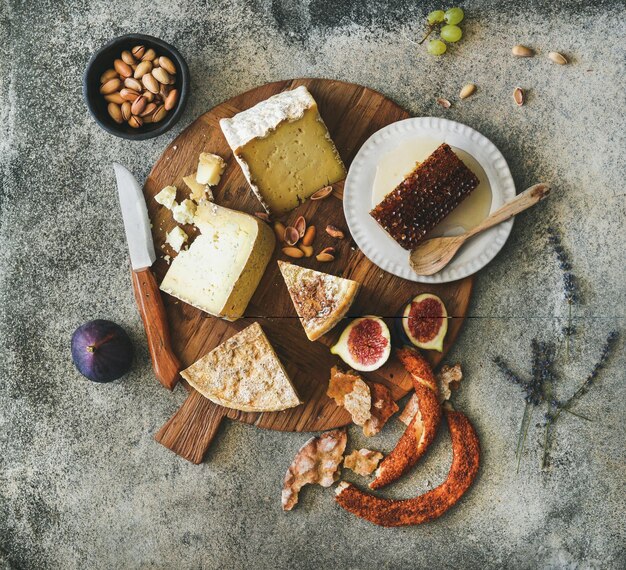 Flatlay de surtido de quesos higos pan de miel y frutos secos