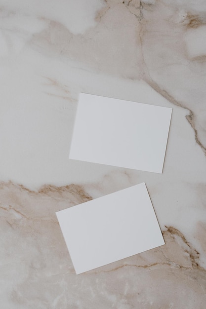 Flatlay de tarjeta de papel en blanco sobre fondo de mármol beige neutro Plantilla de negocio Vista superior plano minimalista estético lujo bohemio concepto de marca comercial