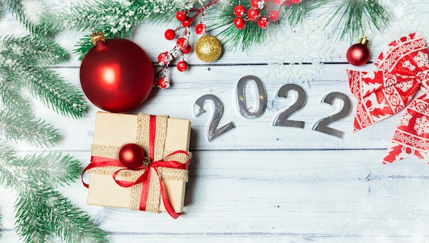 Flatley de Navidad con juguetes de año nuevo de regalo y números 2022 sobre un fondo de madera clara
