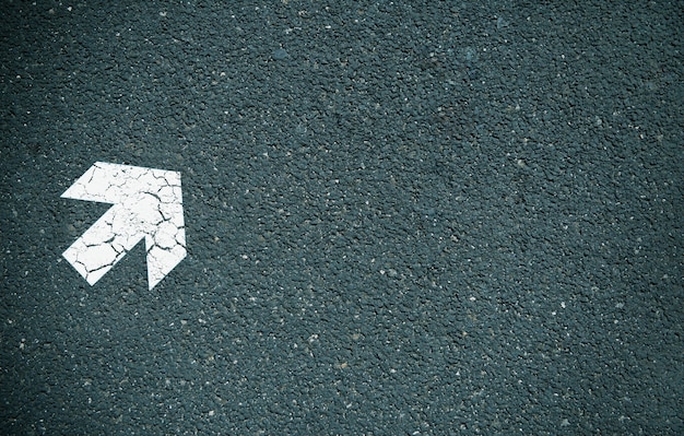 Foto flecha blanca pintada sobre asfalto