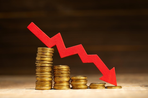 Flecha roja hacia abajo Pila de monedas de oro reduce el concepto de pérdida de dinero