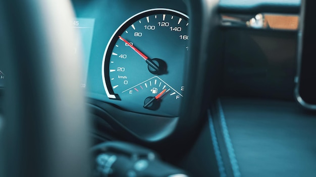 La flecha roja brillante en el velocímetro ubicado en el tablero del automóvil sube mostrando el aumento de la velocidad automática y el indicador muestra el nivel de gasolina, primer plano