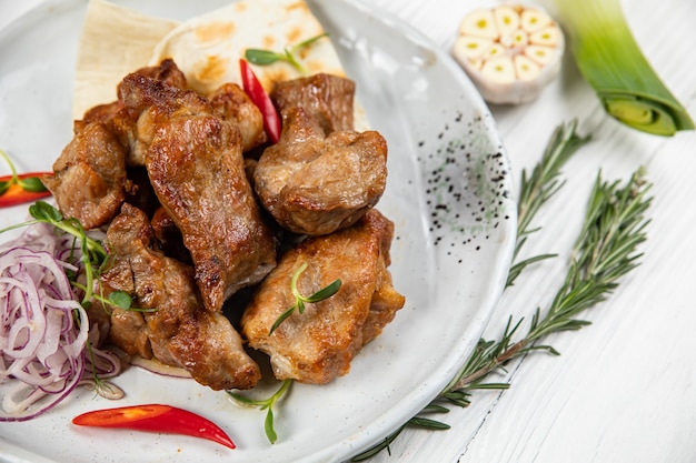 Fleisch auf Fladenbrot mit Knoblauch auf einem hölzernen Hintergrund