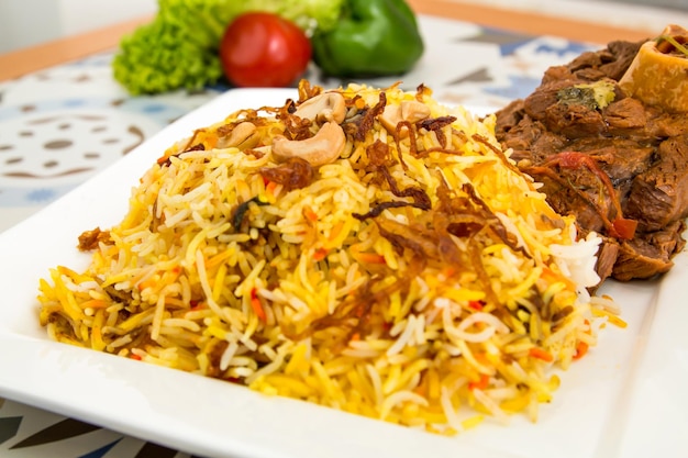 Fleisch Biryani Reis mit Cashew-Nuss serviert in einem Gericht isoliert auf dem Tisch Blick auf arabisches Essen