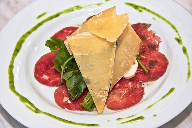 Fleisch Carpaccio mit Parmesan Käse Rucola und Pilze auf weißem Teller Deli-Lebensmittel