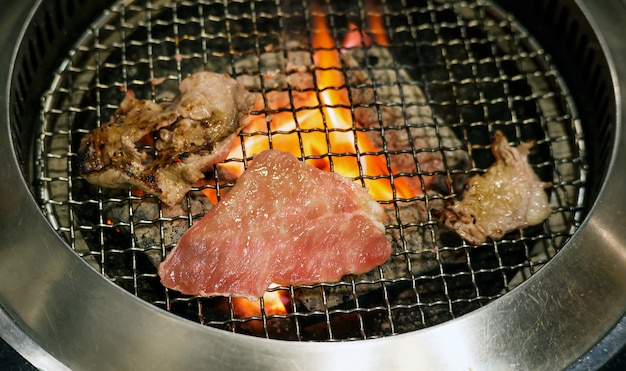 Fleisch, das auf einem Holzkohlegrill grillt.