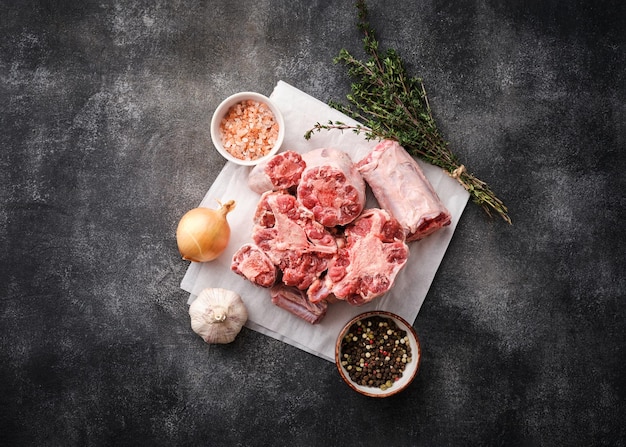 Fleisch für Stierschwanzeintopf auf dunkler Tafel Frischer roher Ochsenschwanz geschnitten Rustikaler Stil