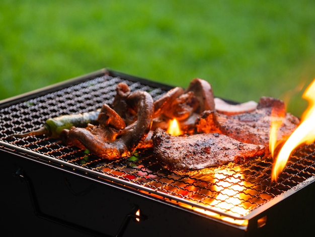 Fleisch gegrillt im Grillkorb auf Holzkohleofen