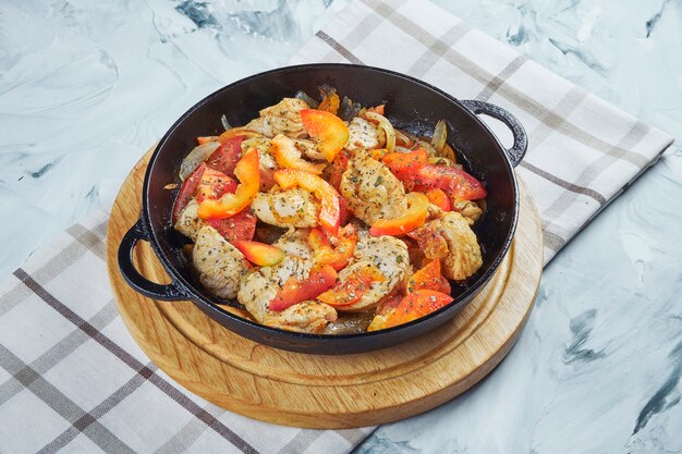 Fleisch Hühnerpfanne mit Tomaten und Paprika und gebratenen Zwiebeln.