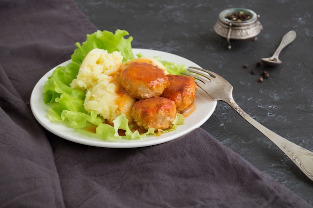 Fleischbällchen in süß-saurer Tomatensauce mit Kartoffelpüree.