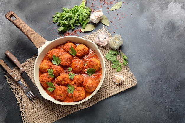 Fleischbällchen in süßer Tomatensauce mit Gewürzen in einer Pfanne serviert