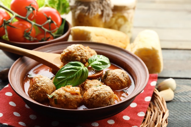 Fleischbällchen mit Tomatensauce, Holzlöffel auf Holz